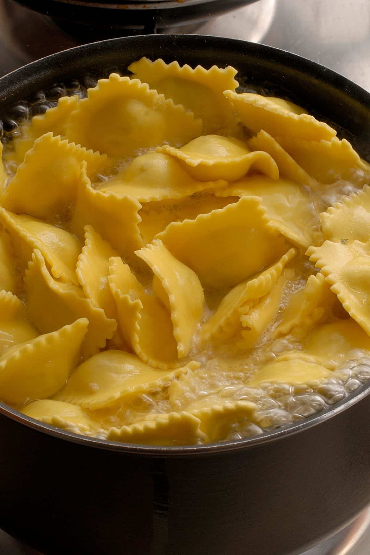 Ravioli coming to the surface in a pot of boiling water. 