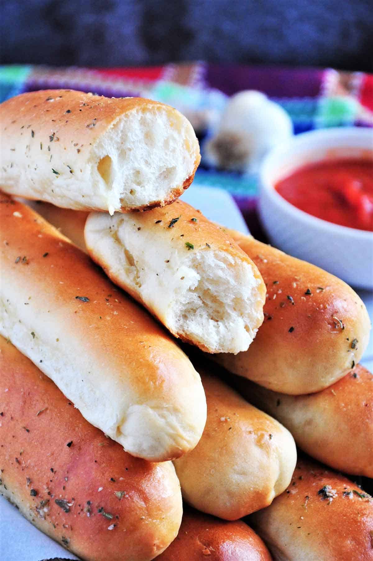 Bread machine breadsticks stacked together with one cut in half. 