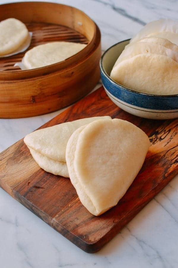 Lotus leaf buns on a cutting board and in a bowl.