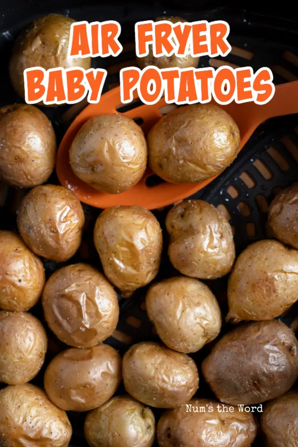 Air fryer baby potatoes with an orange serving spoon picking up a serving. 