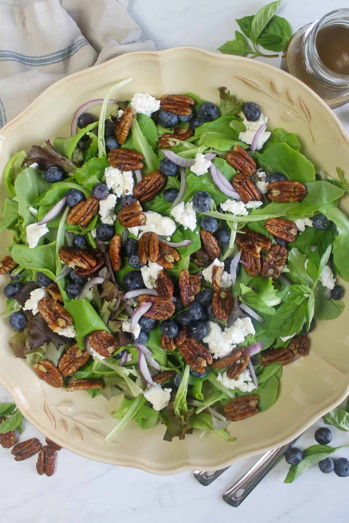 Blueberry goat cheese salad with candied pecans served on a decorative plate. 
