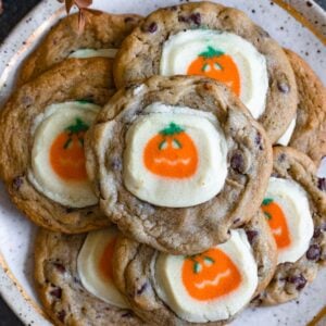 Pillsbury Halloween cookies on a plate, made by putting pumpkin-decorated Pillsbury cookies on top of chocolate chip cookies.