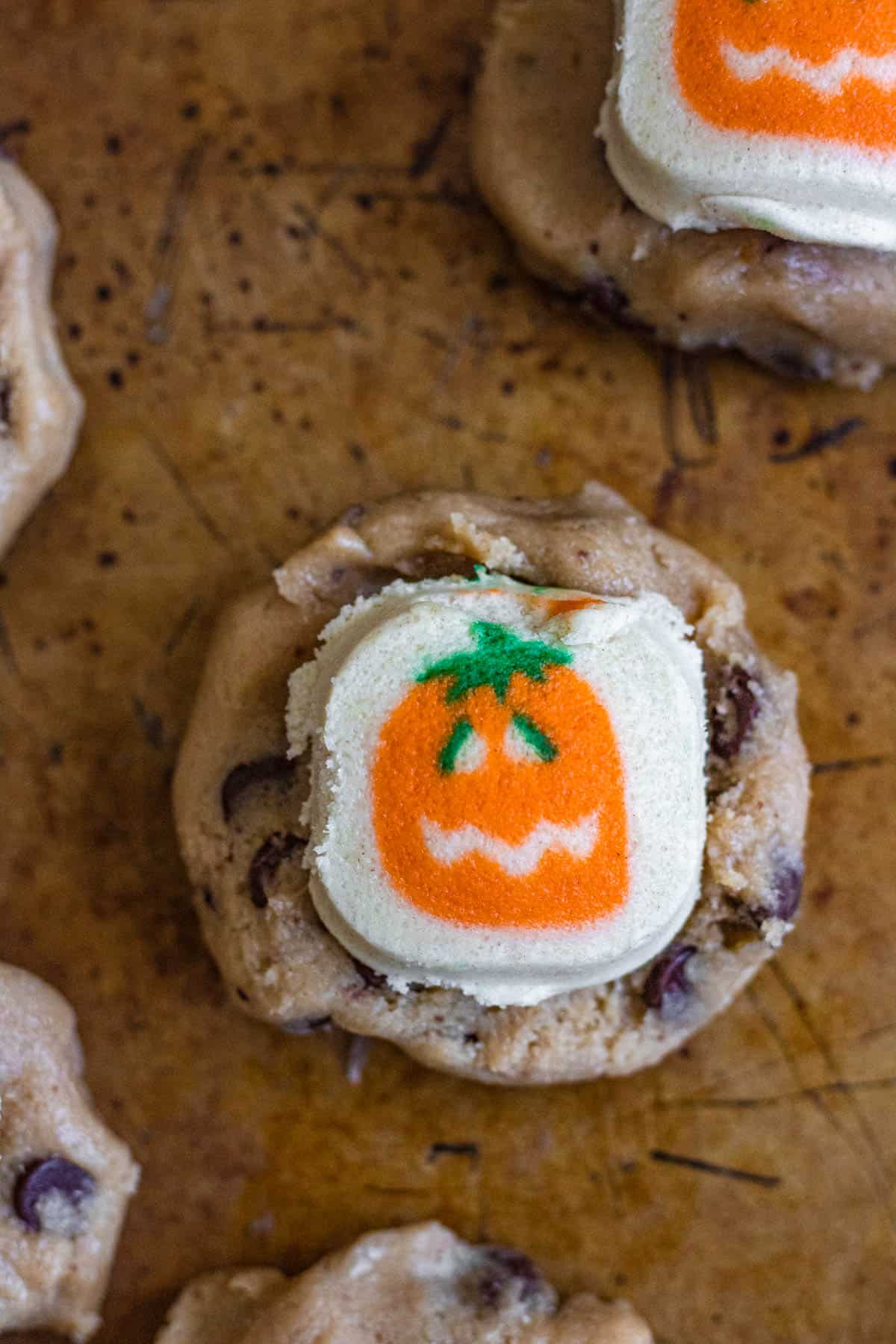 Close up of a chocolate chip cookie dough topped with halloween sugar cookie dough ready to bake. 
