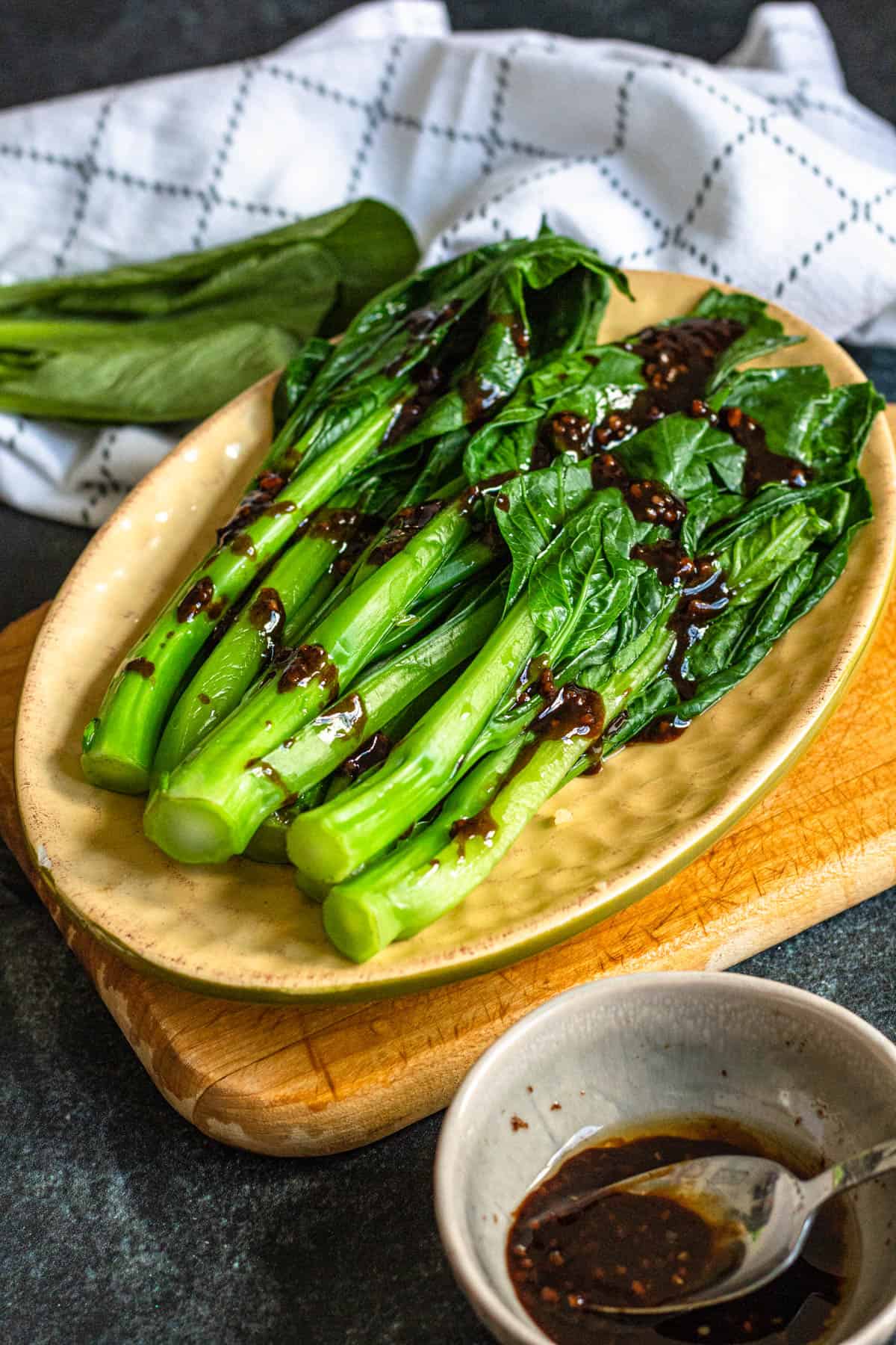 Yu choy with sauce drizzled over it. 