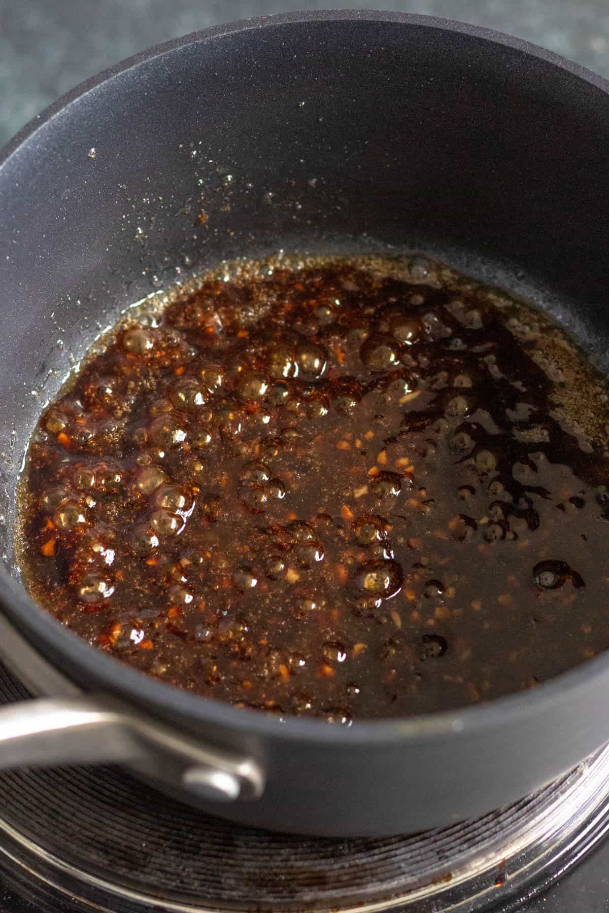 Soy sauce and oyster sauce added to the pan with the minced garlic. 