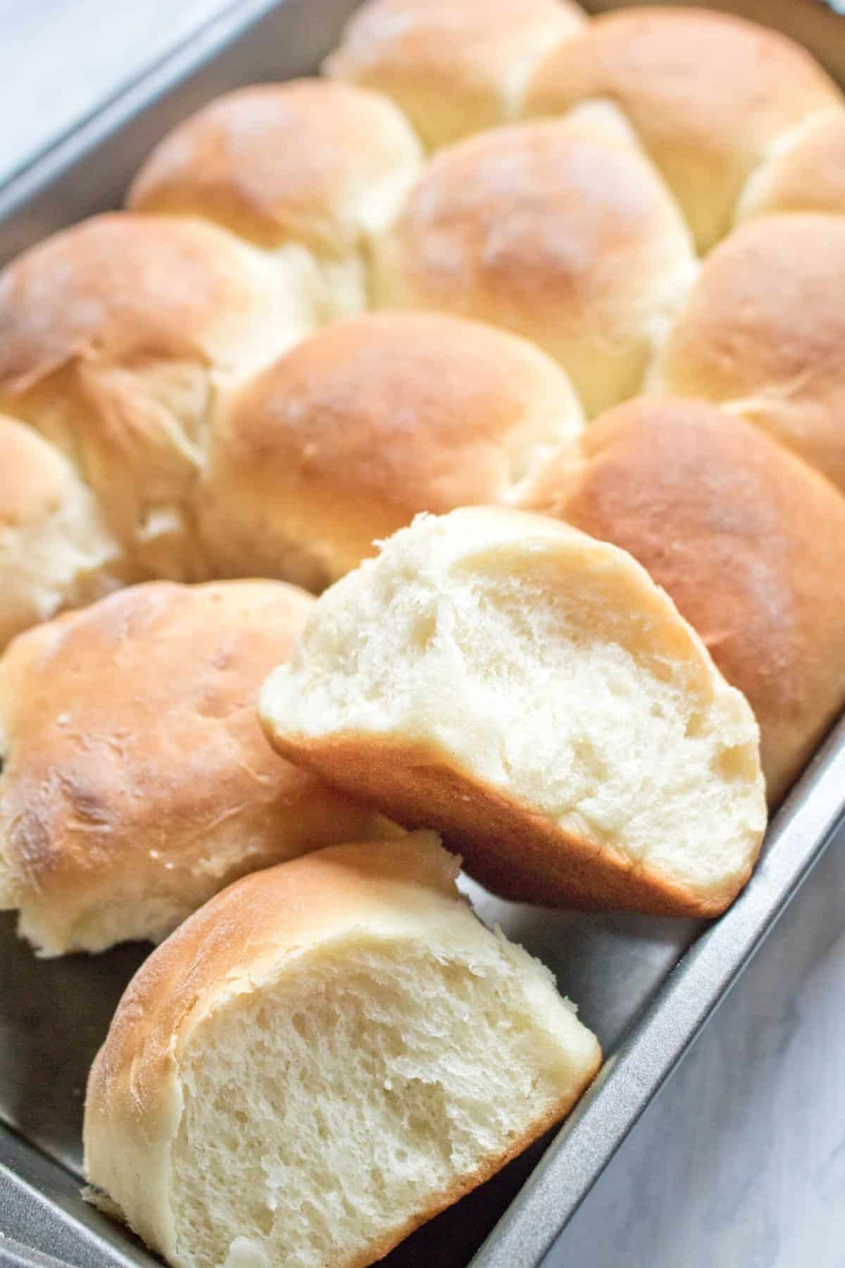 A pan filled with baked dinner rolls made from scratch. 