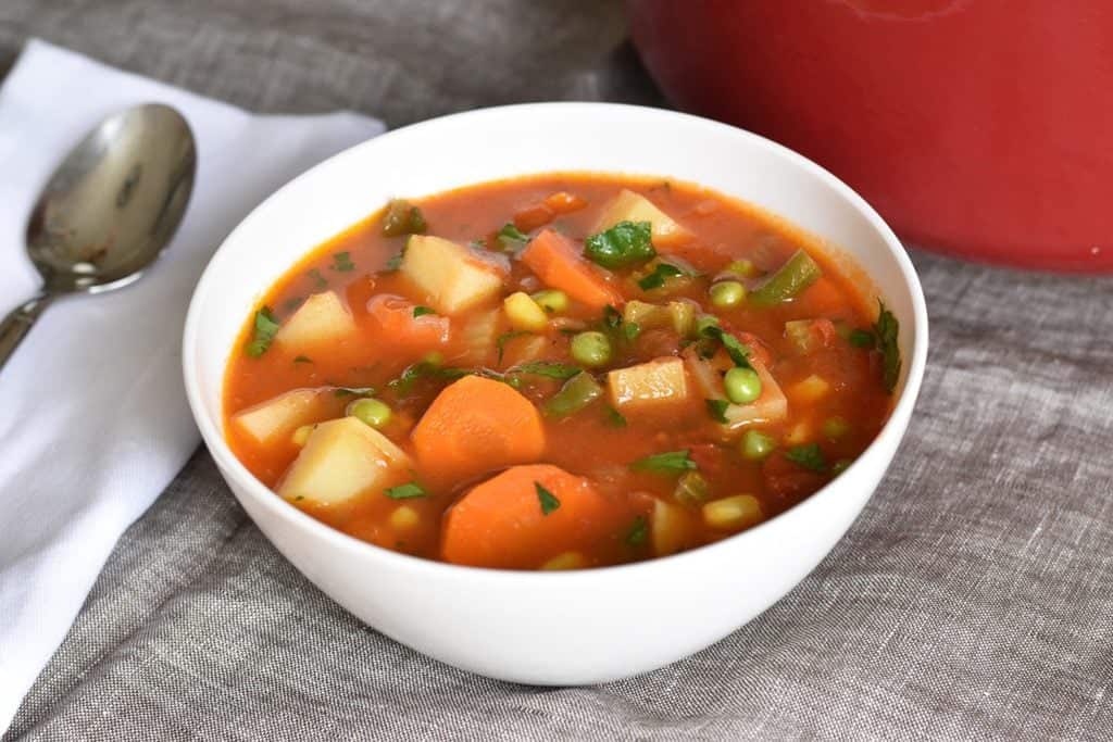 Vegetable soup with a spoon next to it. 