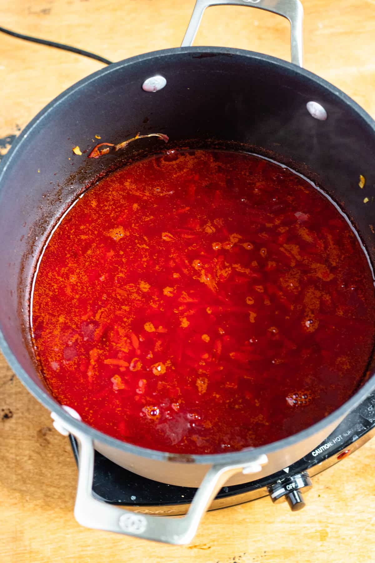 Cooked and bubbling red soup in a large soup pot