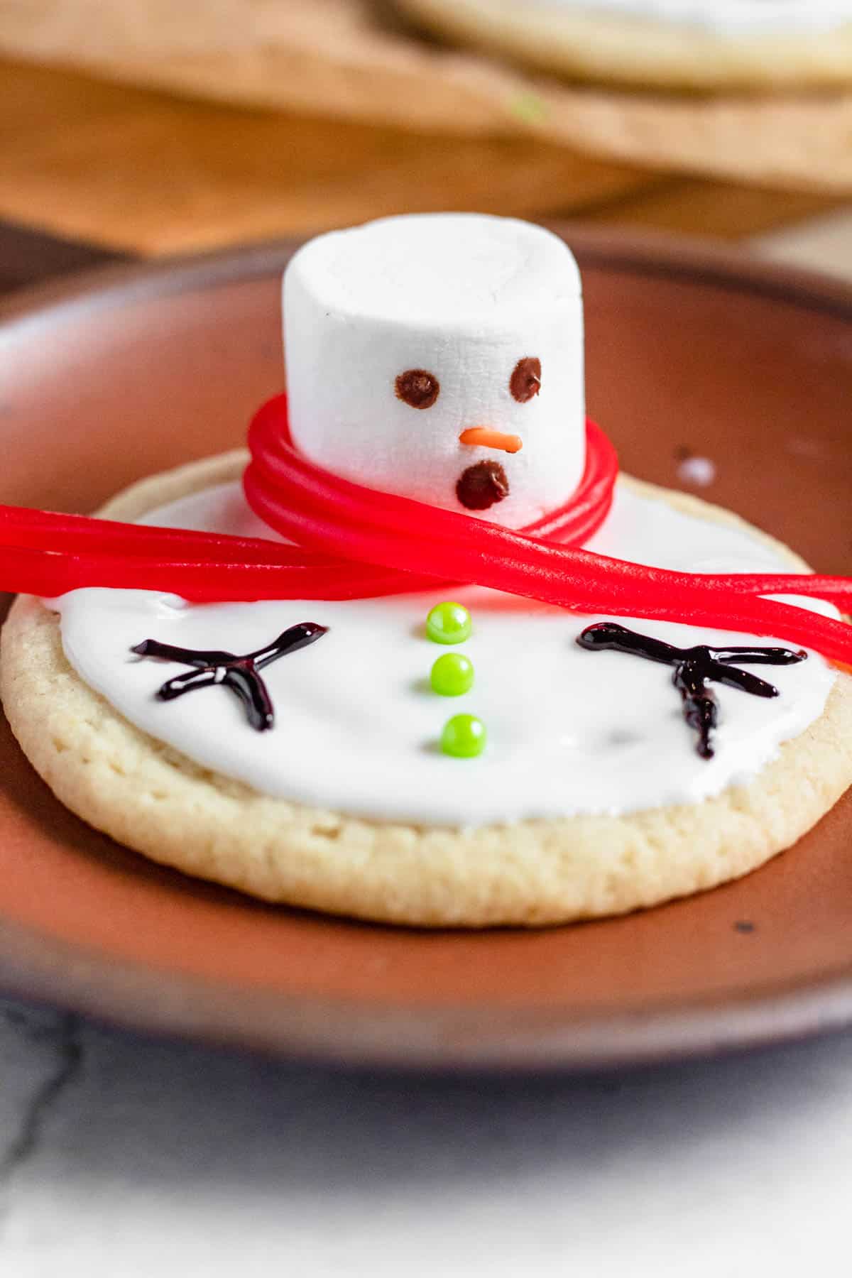 Close up of a melted snowman cookie all decorated. 