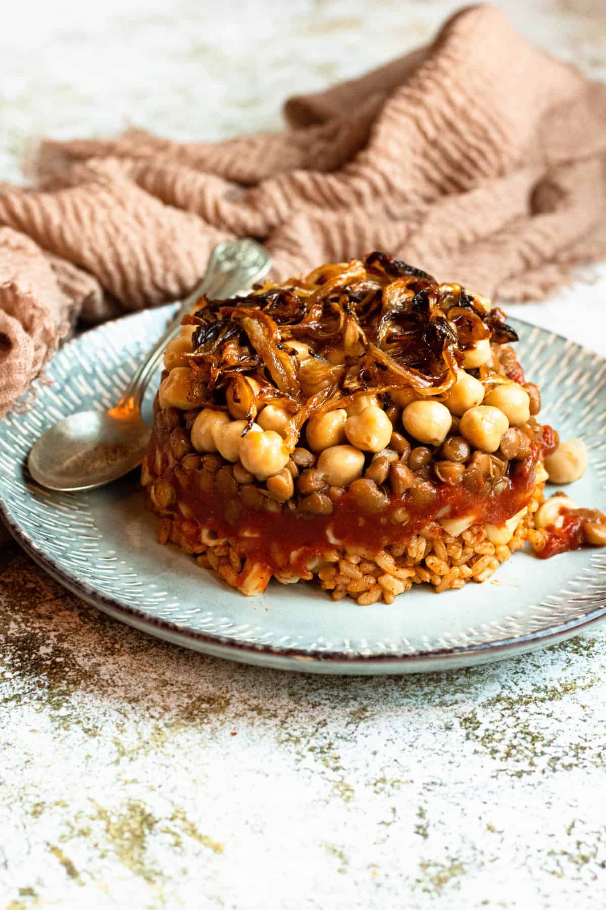 Koshari stacked and served on a plate. 