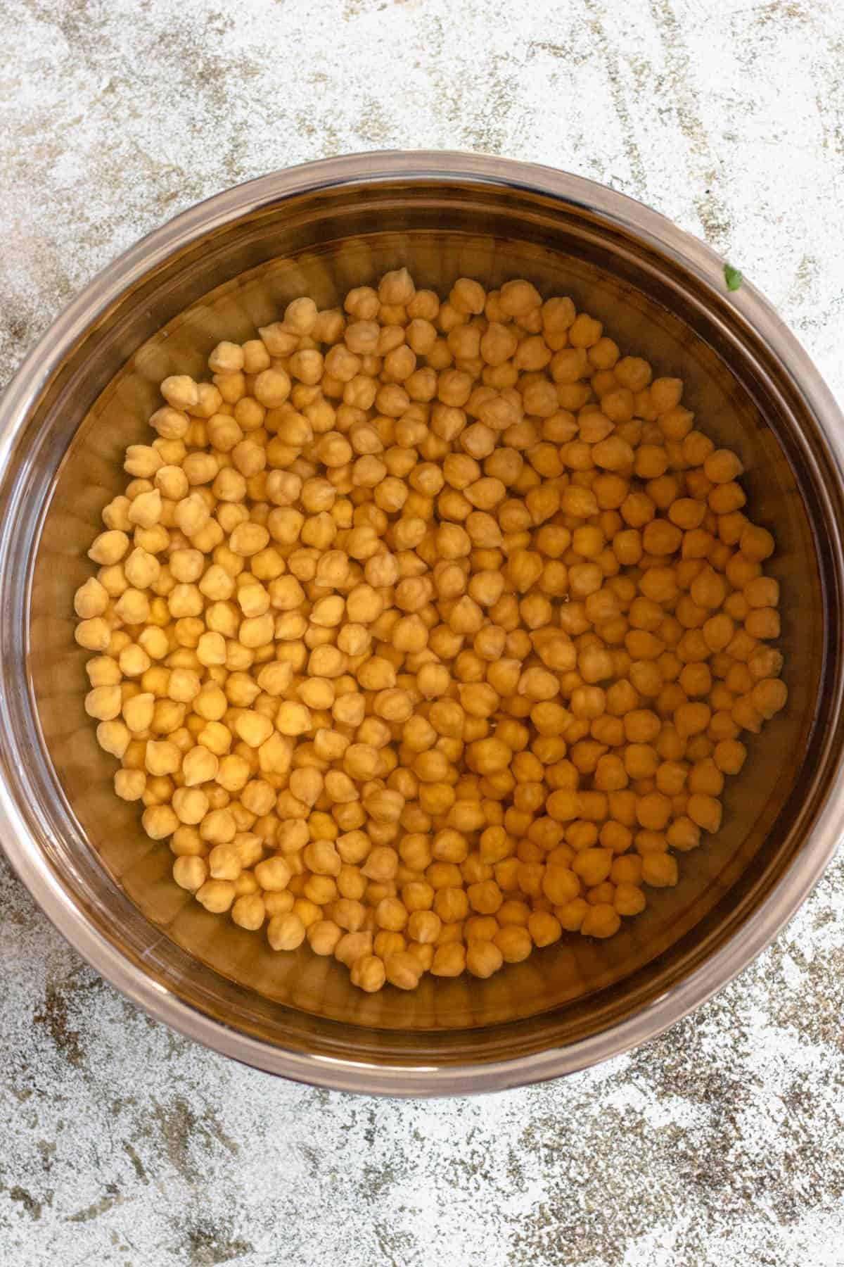Chickpeas covered in water in a bowl. 