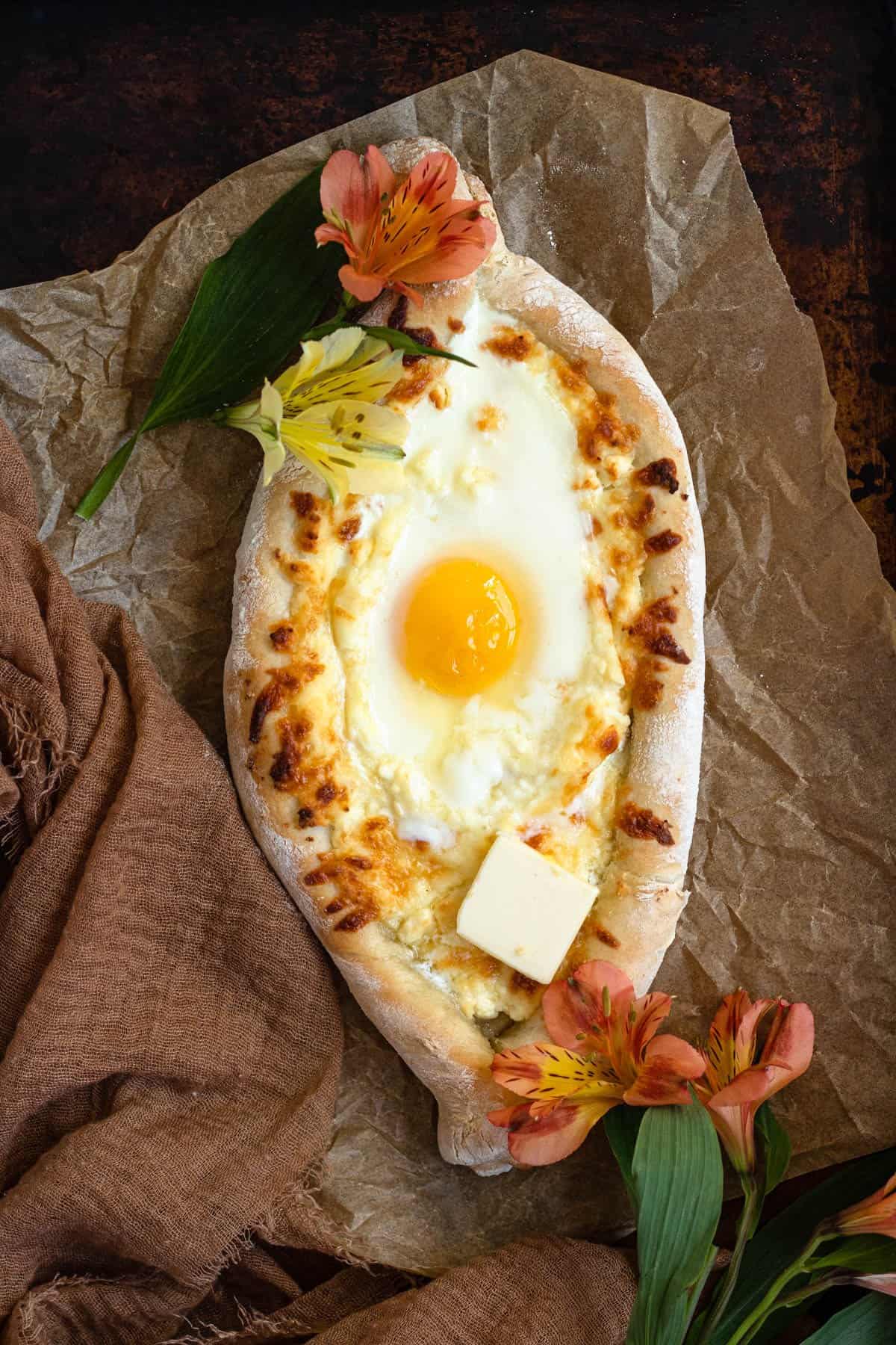Khachapuri laying on parchment paper. 