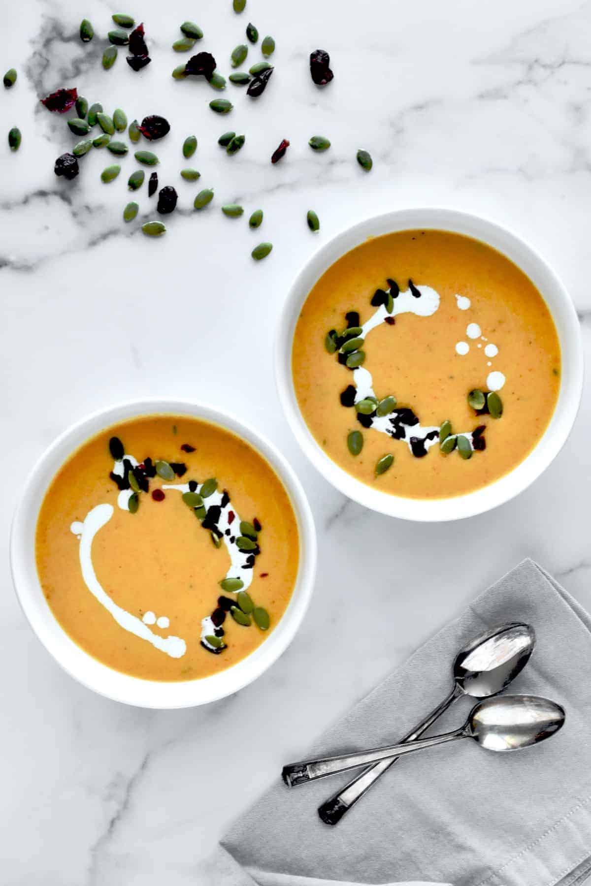 Butternut squash, carrot ginger soup with pumpkin seeds and raisins garnished on top. 