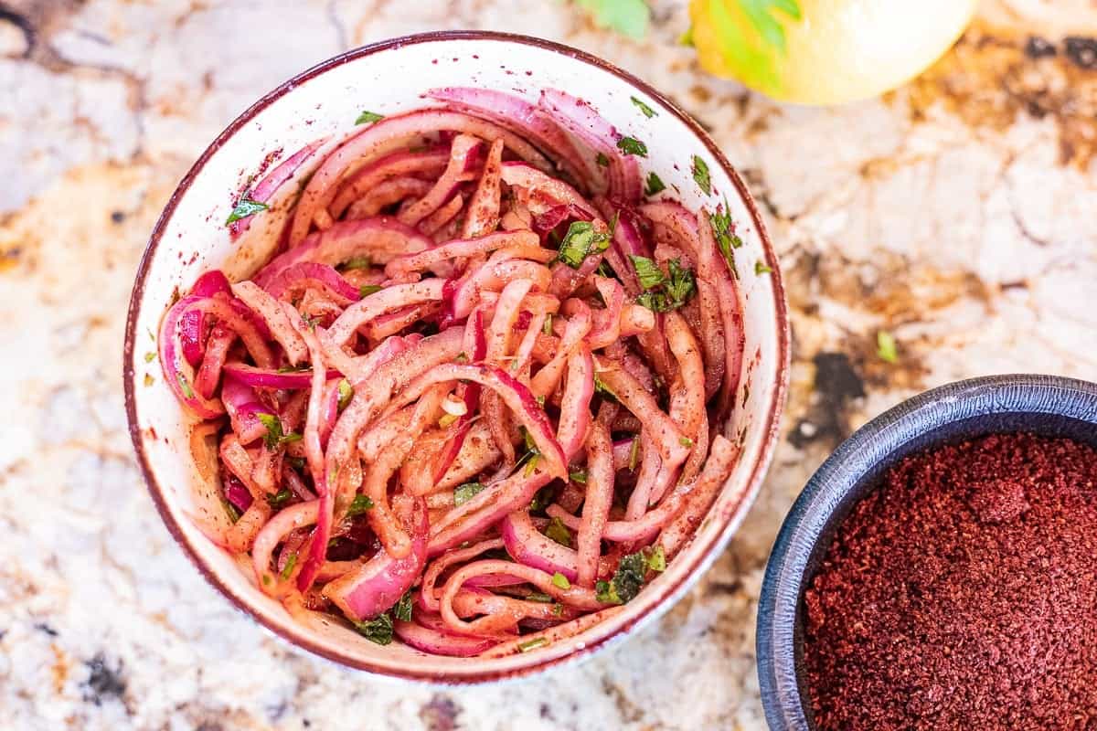 Marinated sumac onions in a small bowl. 