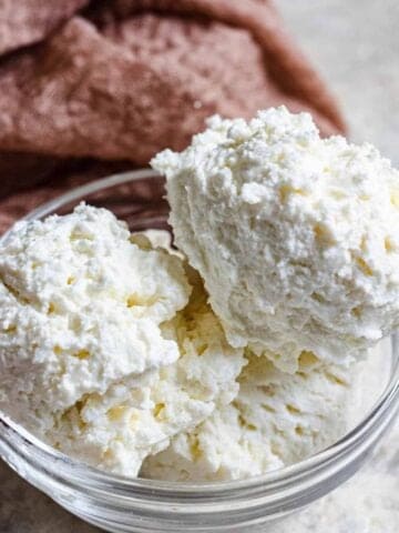 Scoops of ricotta in a glass bowl.