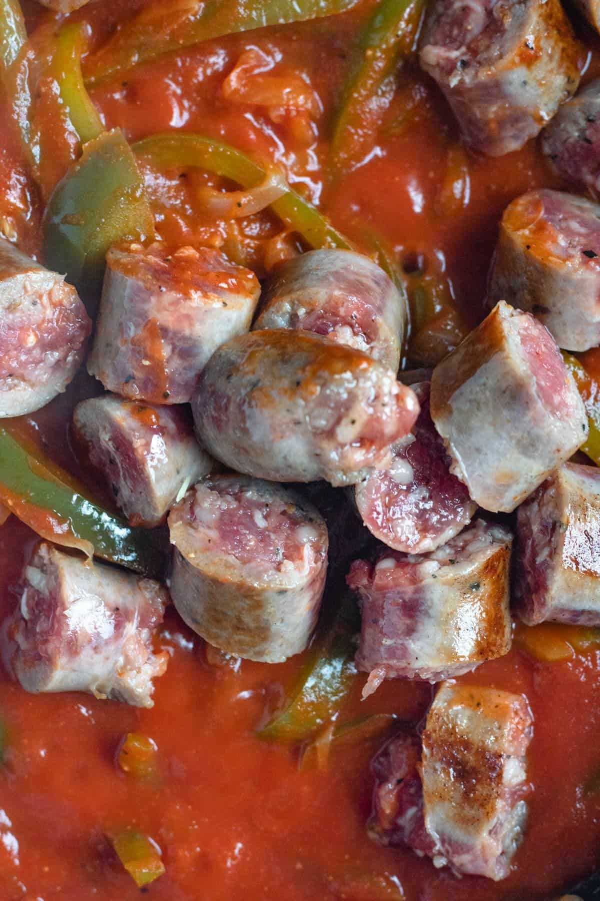 Close up of sliced up italian sausages in the tomato sauce. 