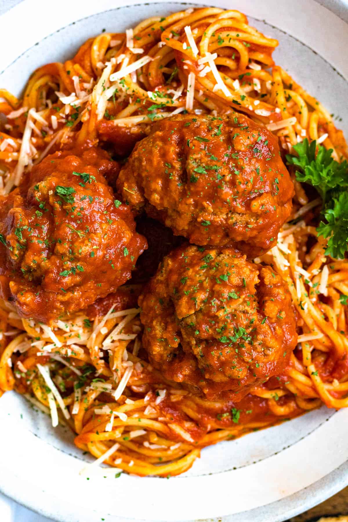 Top view of soft meatballs recipe served over spaghetti and sauce. 