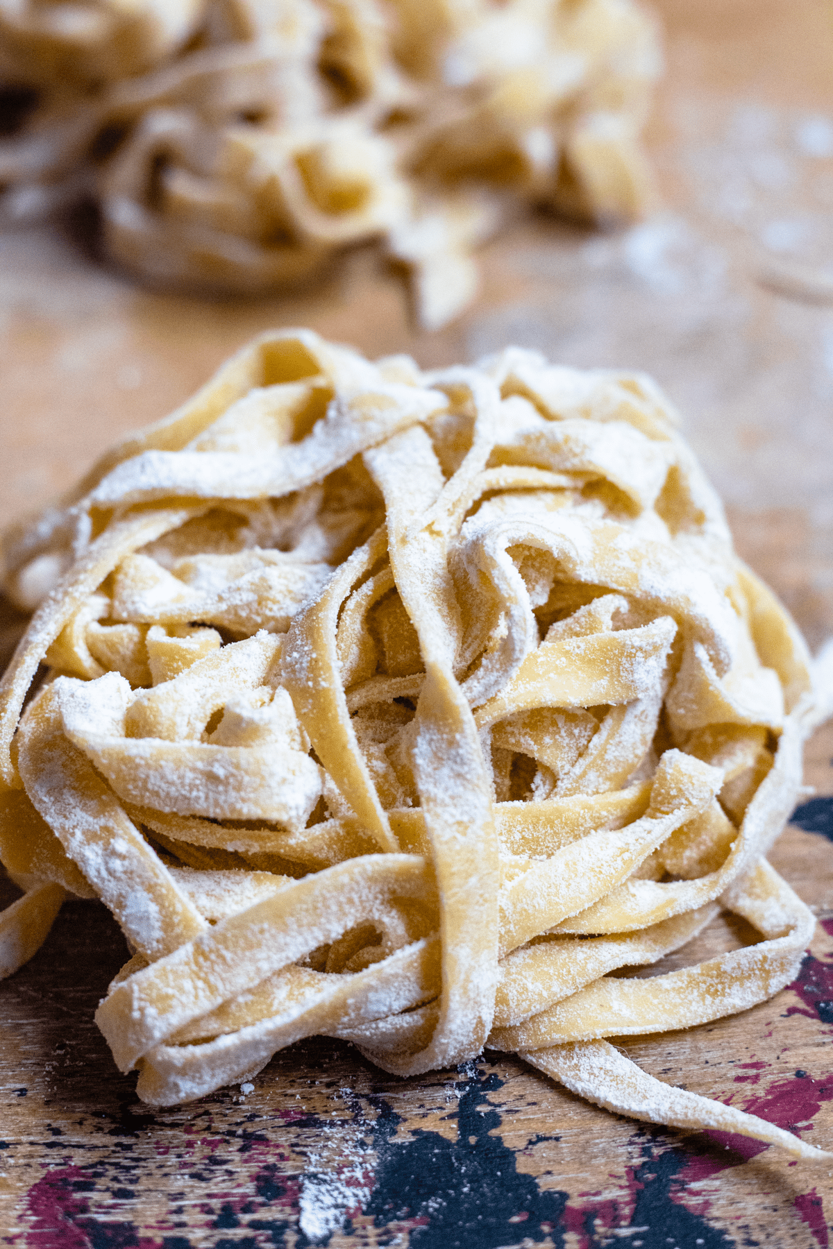 Piles of homemade pasta dough drying on a baking sheet. 