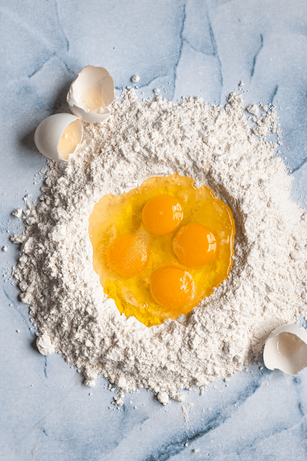 A pile of flour with a well in the middle, filled with eggs. 