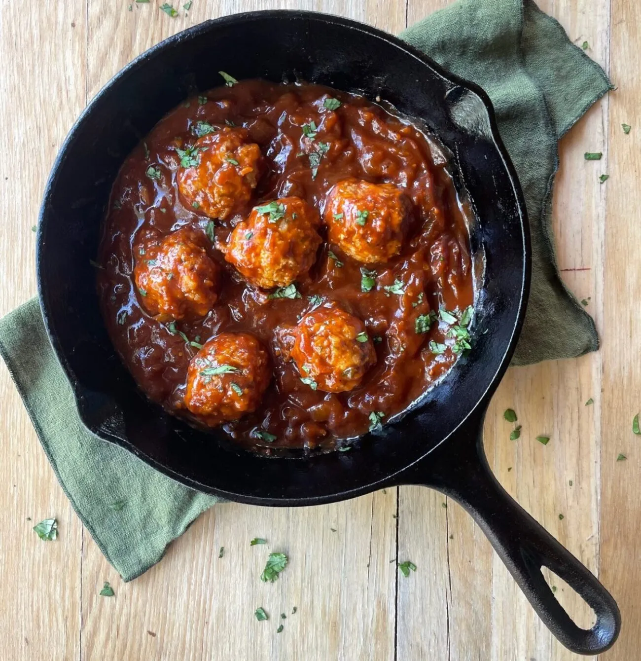 Braised bbq meatballs in a cast iron pan.