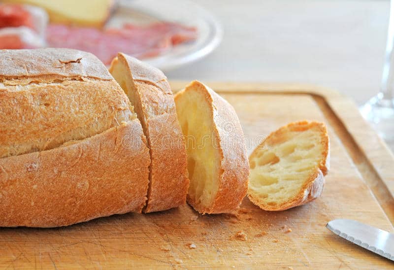 Italian loaf with a few slices on a cutting board. 