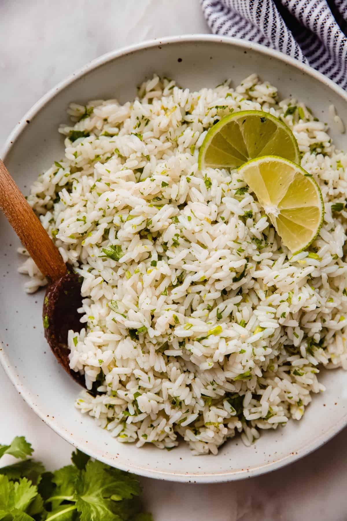 Better than chipotle's cilantro lime rice garnished with lime slices in a bowl. 