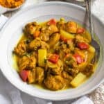 Bowl of Jamaican chicken curry with a fork resting in it.