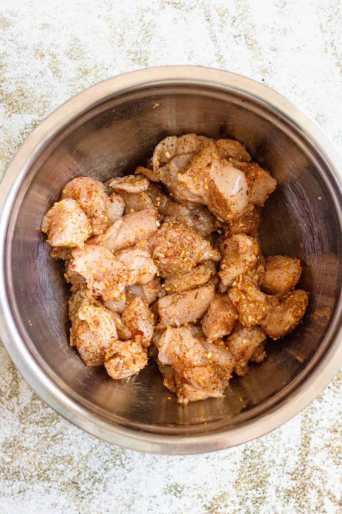 Bowl of chicken pieces covered in jerk seasoning. 