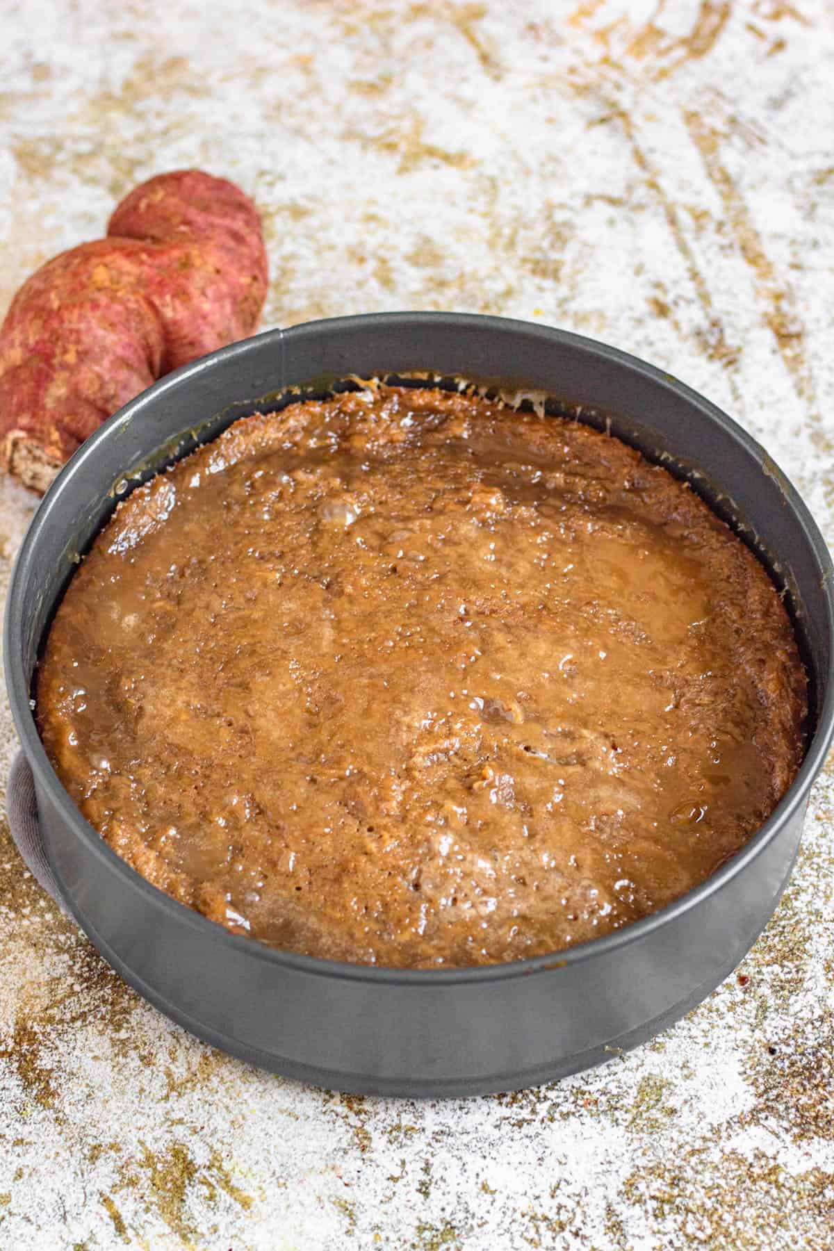 Sweet potato recipe in a circular pan with the glaze soaked in over the cake. 