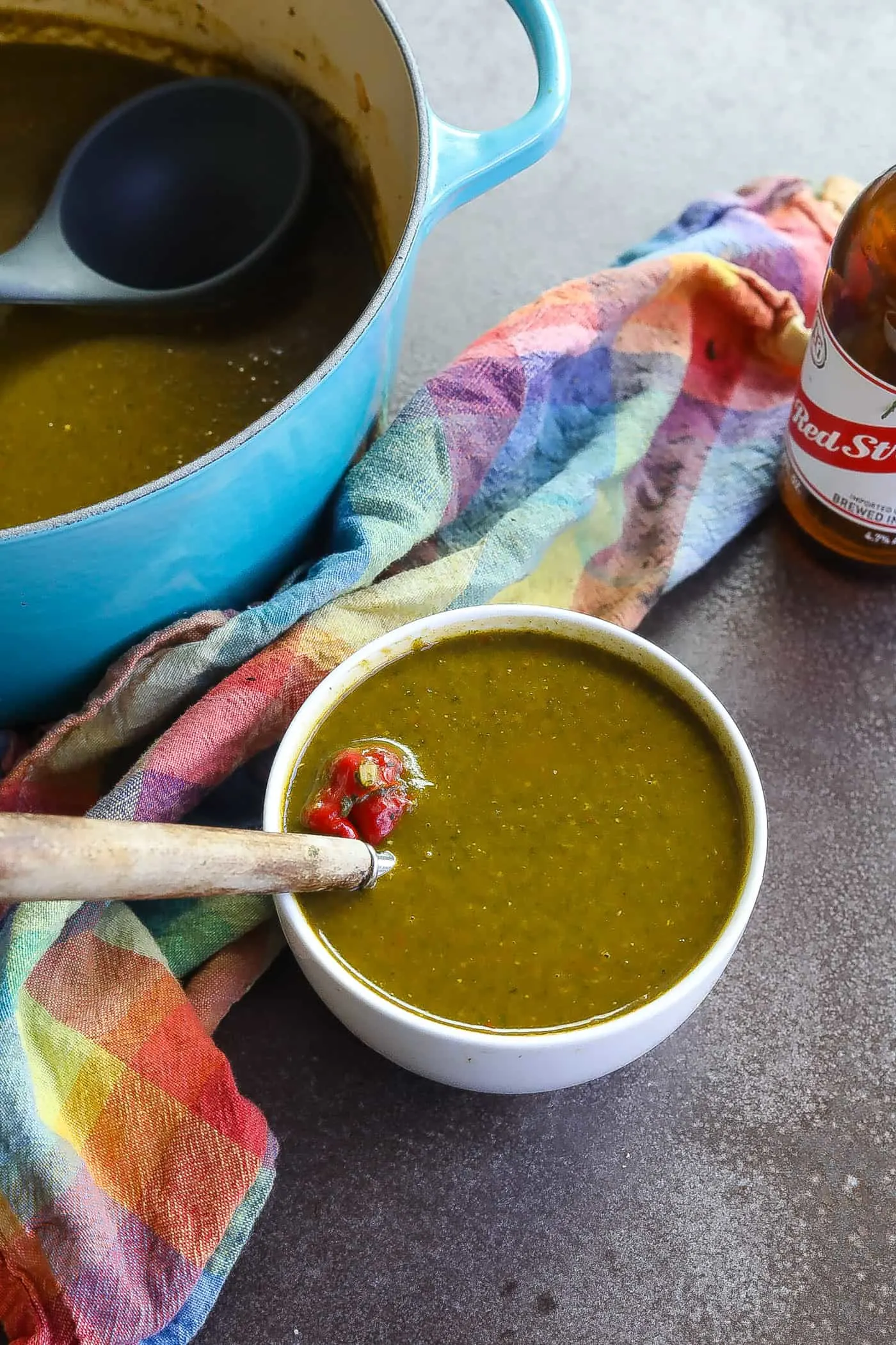 Caribbean callaloo soup with a bottle of Red Stripe beer next to it. 