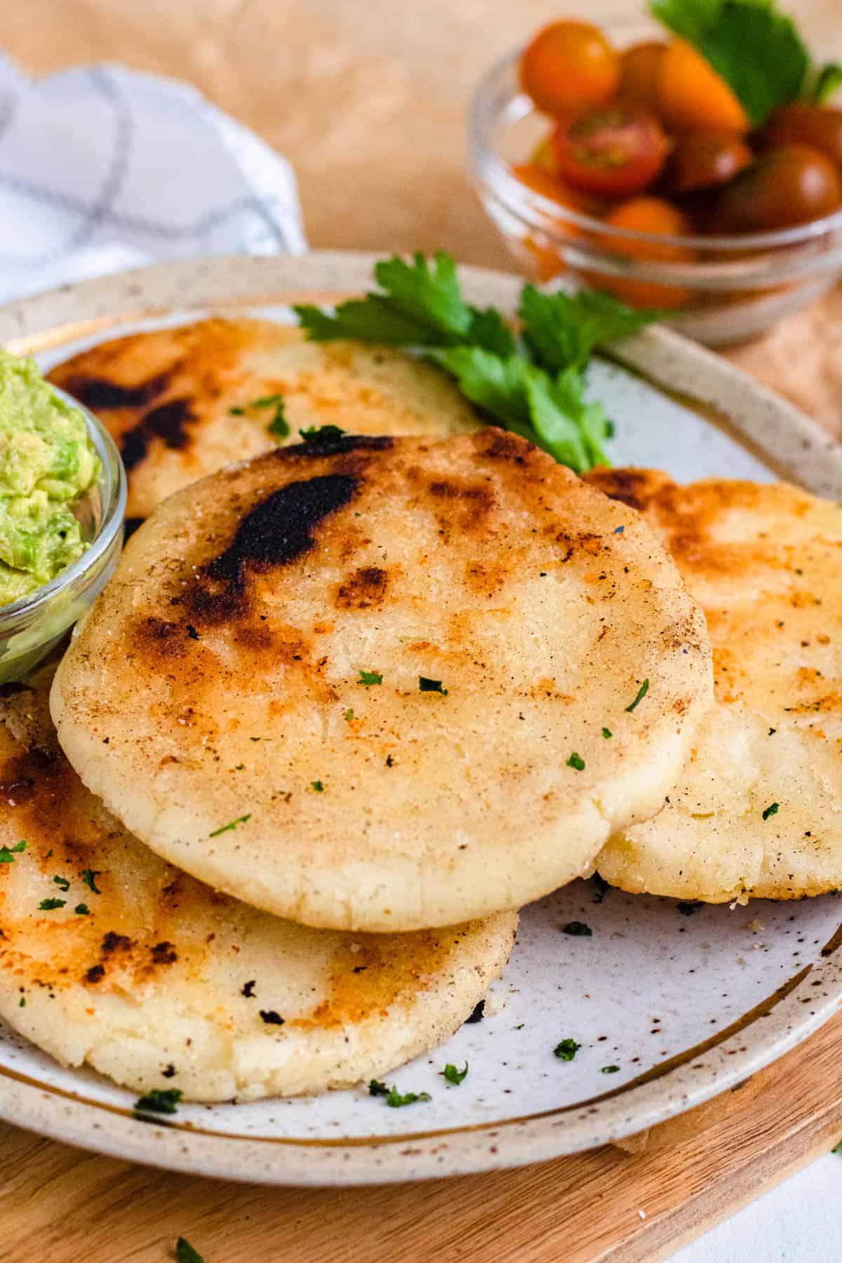 Plate of arepas with a small bowl of guacamole. 