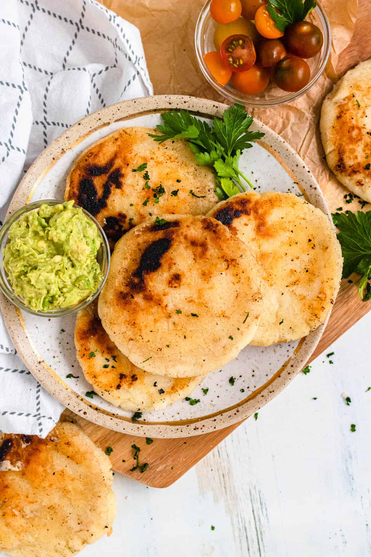 Plate of 4 arepas recipe from colombia with a small bowl of guacamole on the plate. 