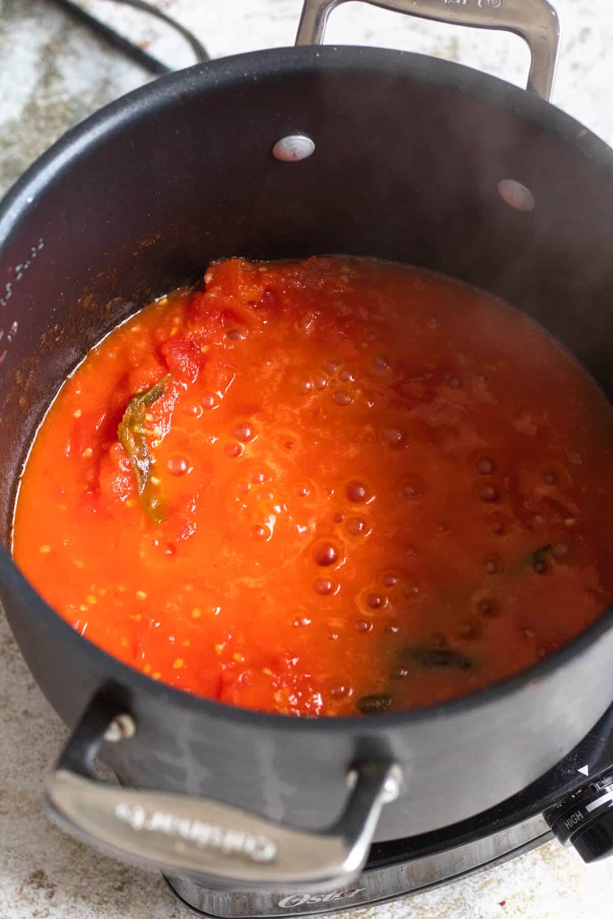 Tomatoes broken down and forming a sauce in the pot. 