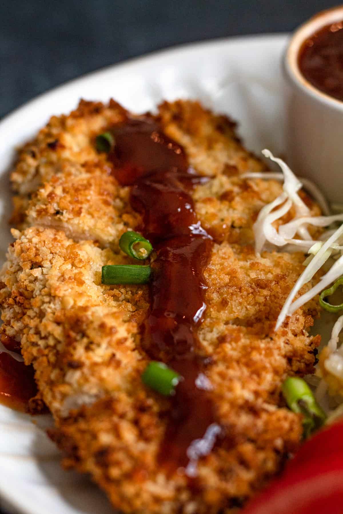 Air Fried Chicken with Katsu sauce on top with sliced green onions garnished over the top. 
