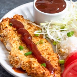 Easy Katsu Sauce drizzled over chicken katsu and served alongside rice and tomatoes.