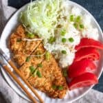 Plate of Air Fryer Katsu with sliced tomatoes, white rice and cabbage served on it.