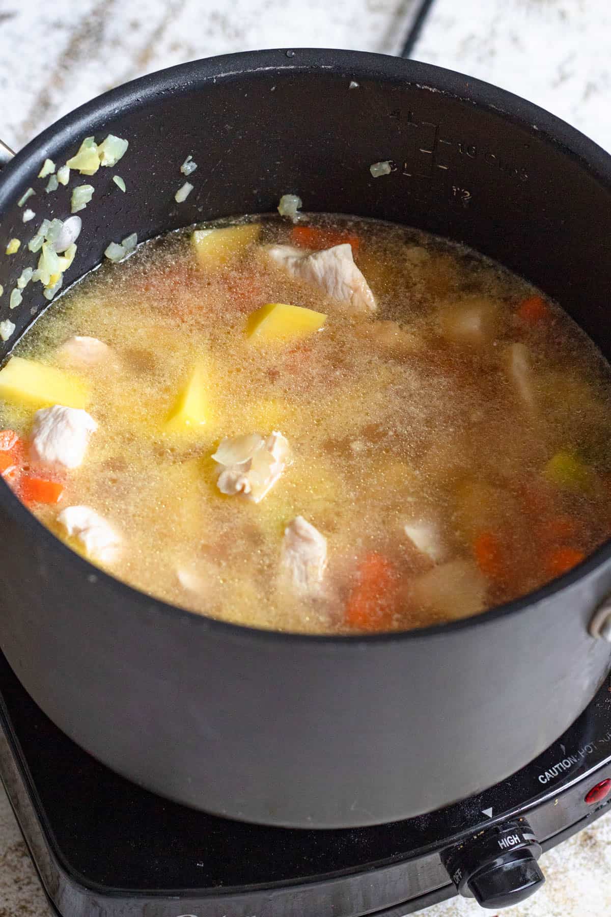 Water added to the pot over the chicken and vegetable mixture. 