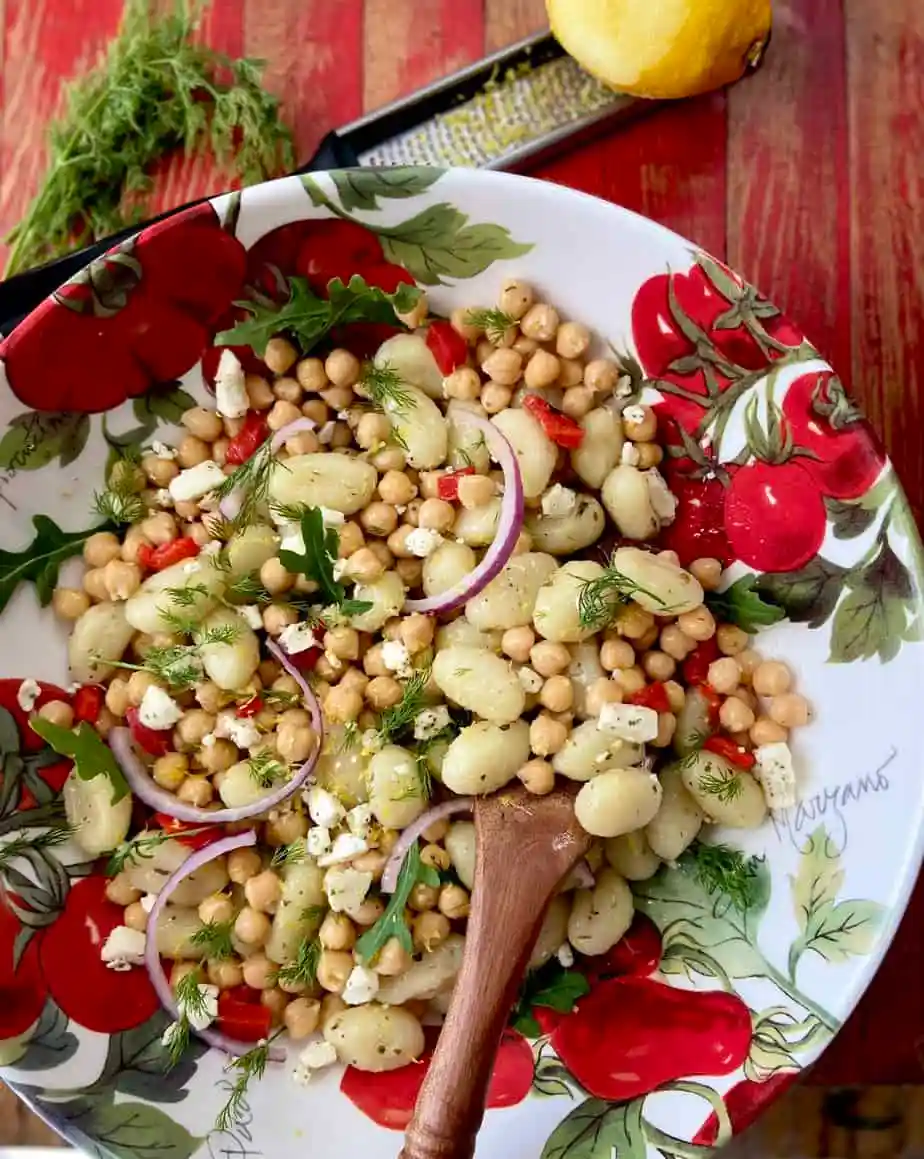 Mediterranean Gnocchi served in a salad bowl with a wooden spoon. 
