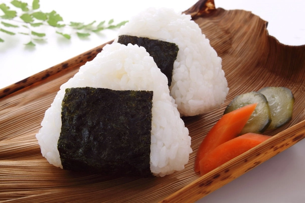 Onigiri served with pickled carrots and cucumbers. 