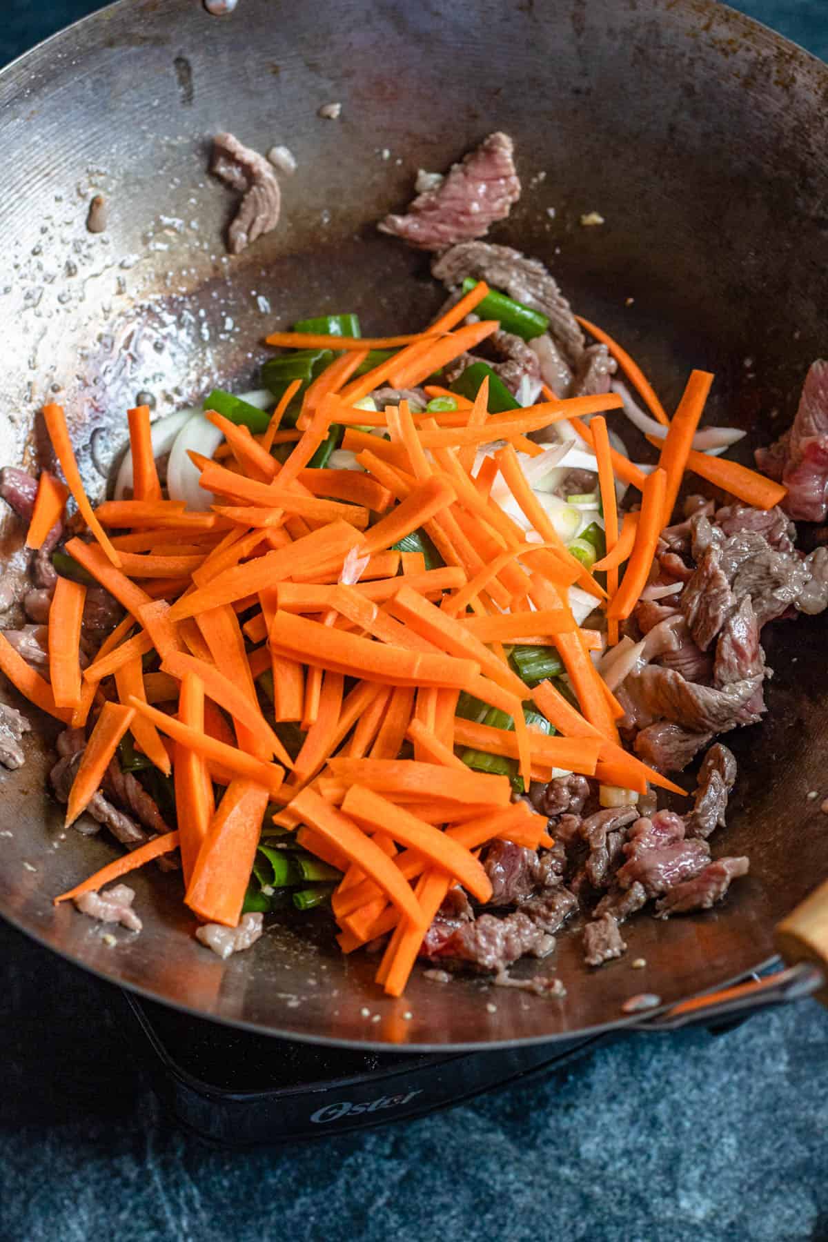 Veggies combined with the beef in a wok. 