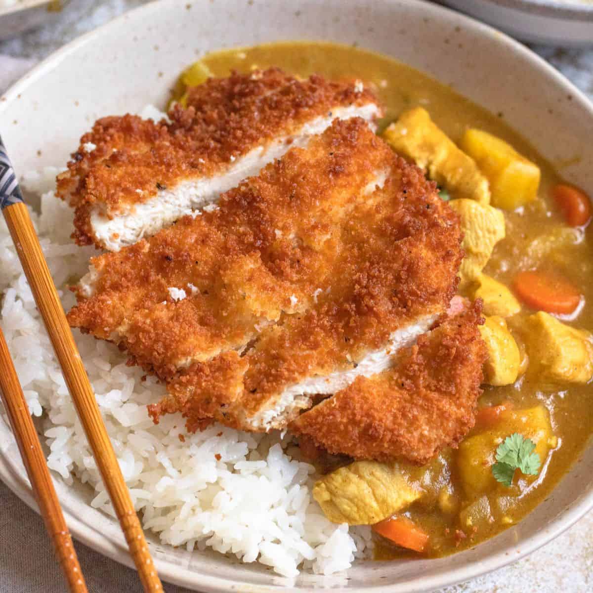 Chicken katsu curry with rice and chopsticks on the side