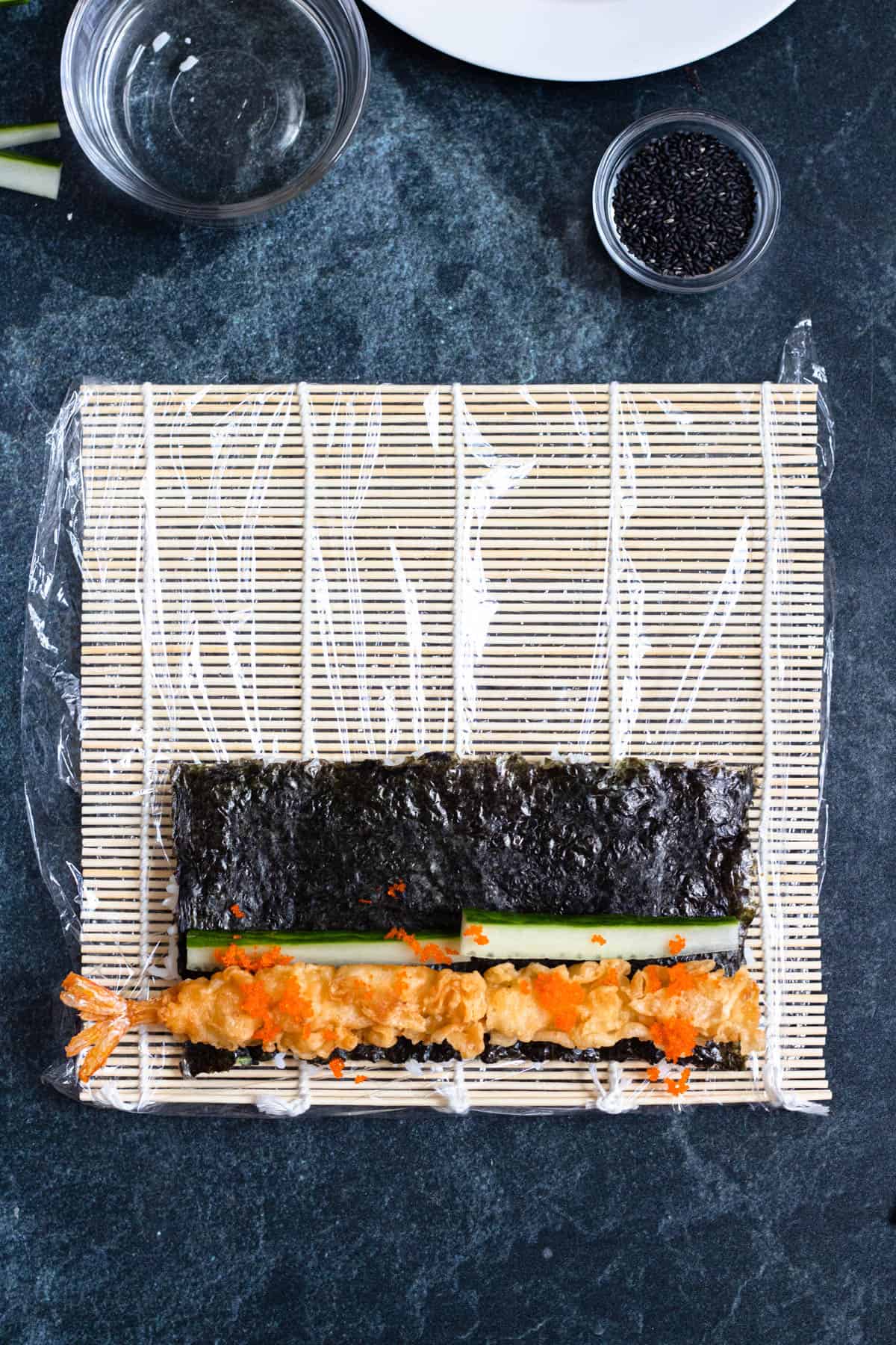Shrimp tempura, cucumber and tobiko added to the nori sheet. 