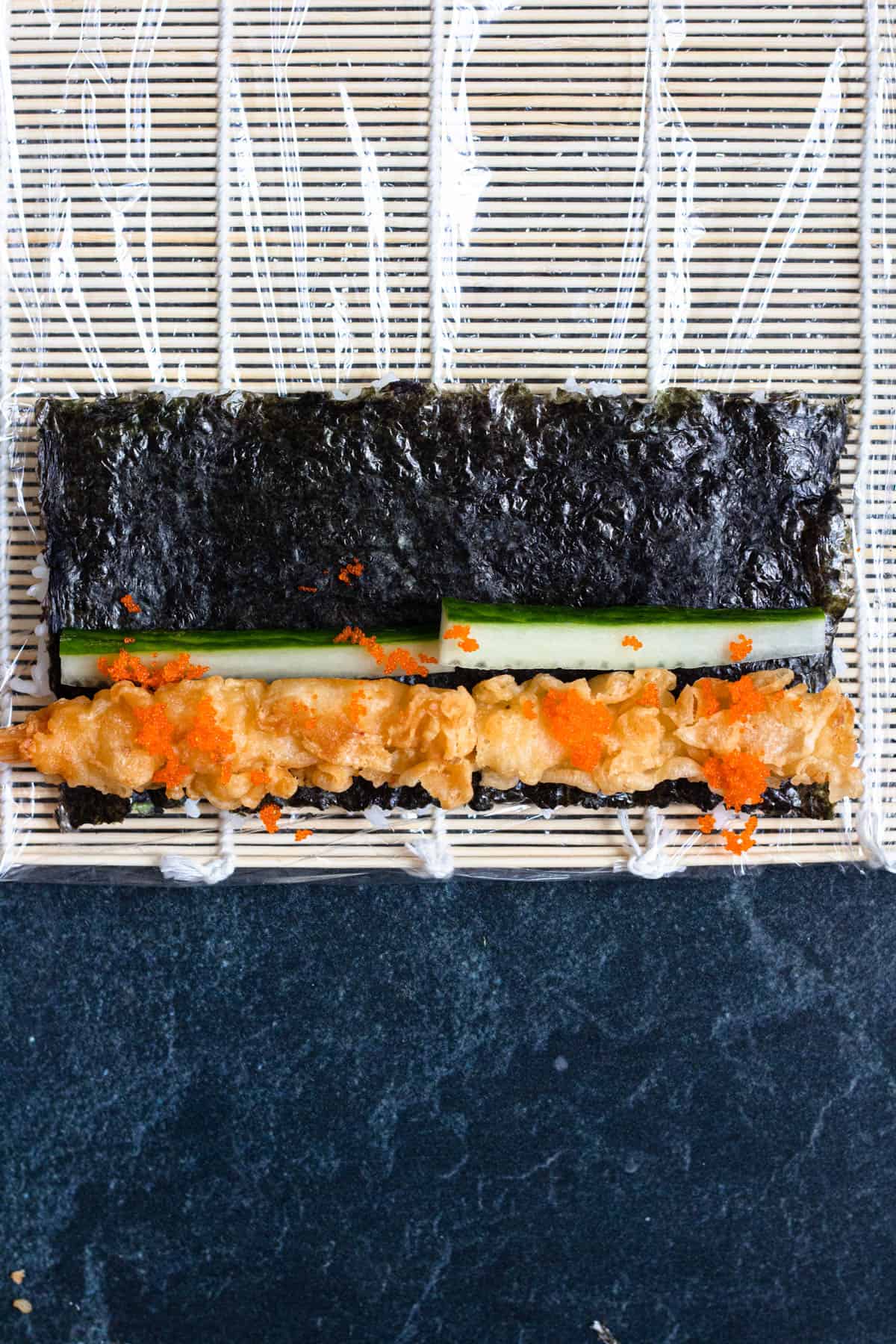 Dragon roll toppings on the nori sheet. 