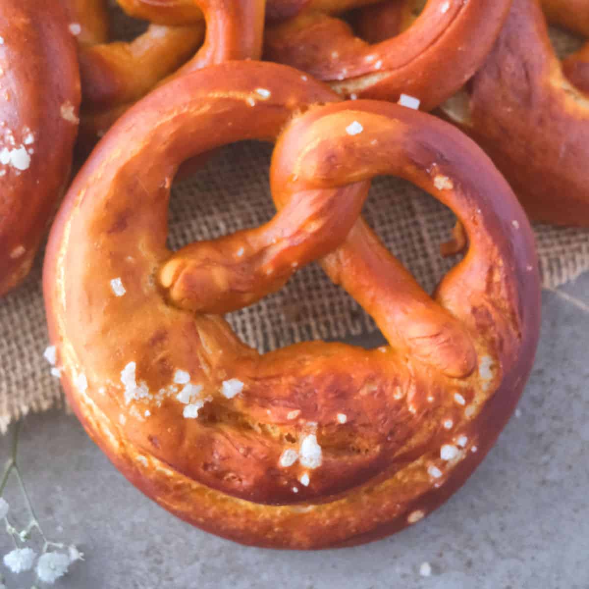 Homemade big German pretzels stacked together with coarse sea salt on top. 