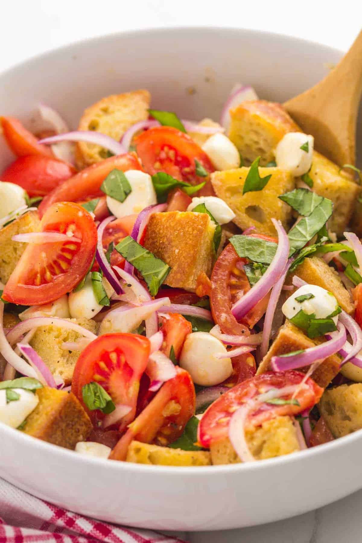 Panzanella Salad in a bowl with salad tongs. 