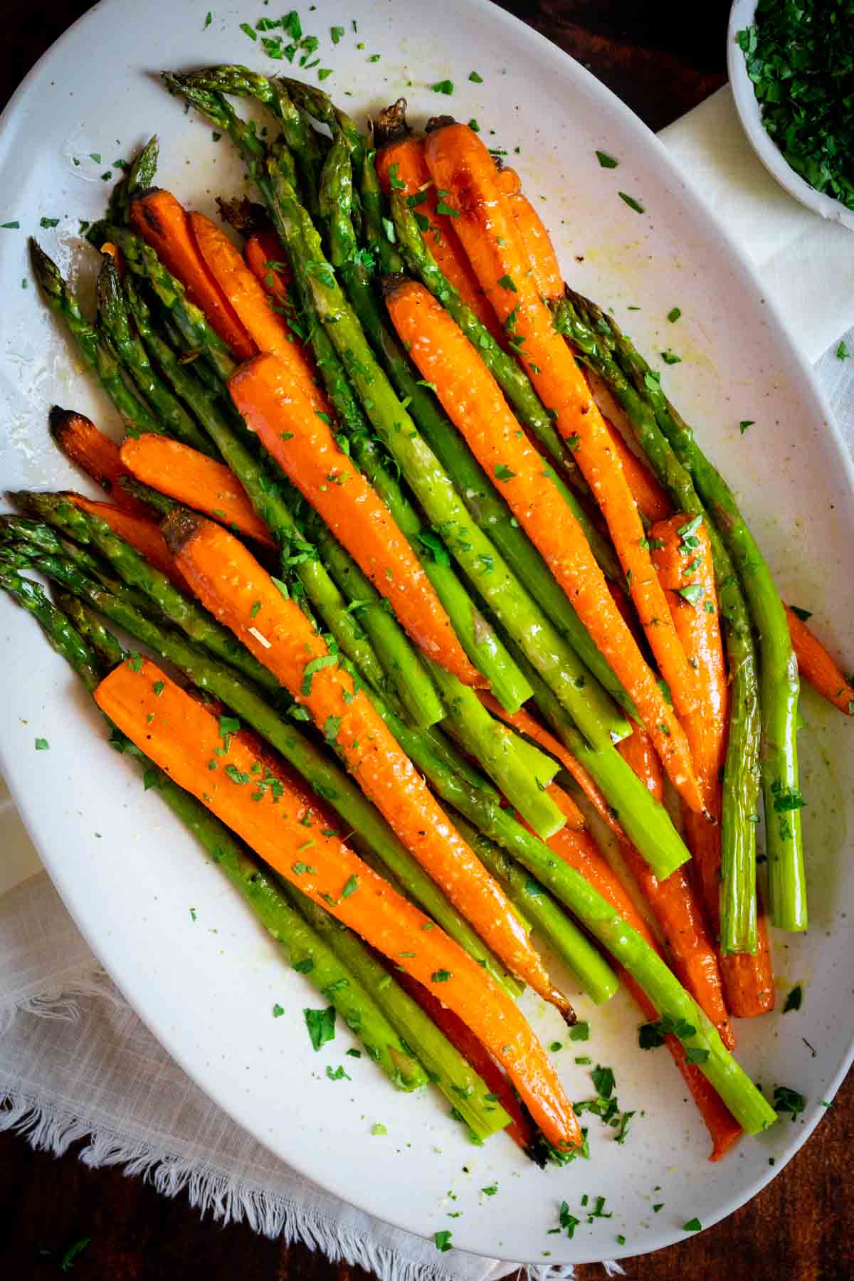 Roasted carrots and asparagus on an oval platter. 
