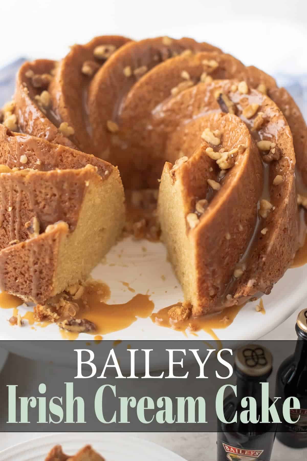 Baileys irish cream cake topped with chopped nuts with a slice removed.