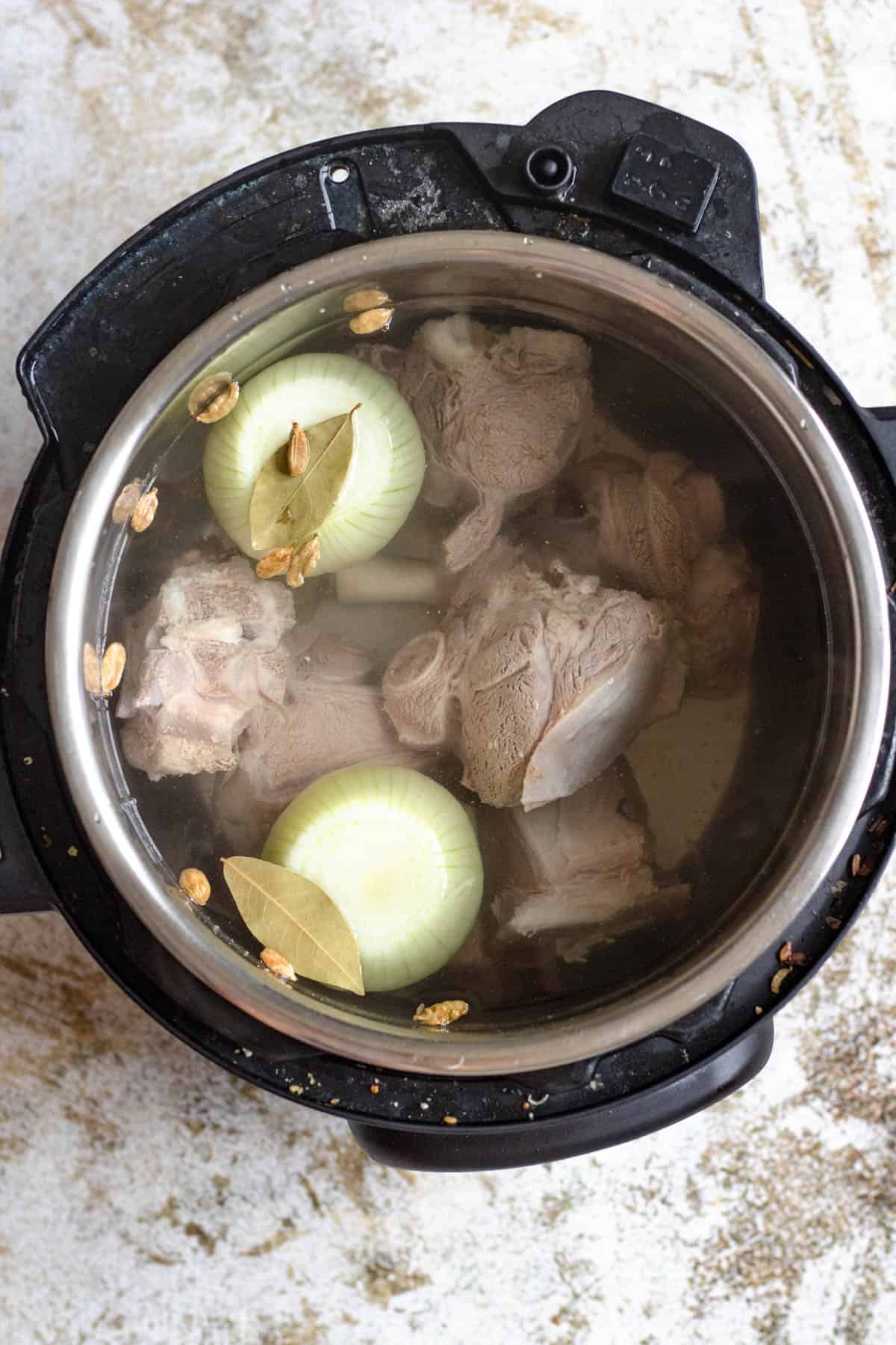 Lamb, onions, bay leaves and water in a pressure pot. 