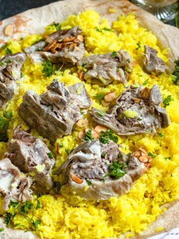 Mansaf on a platter with bread, lamb, and yellow rice.
