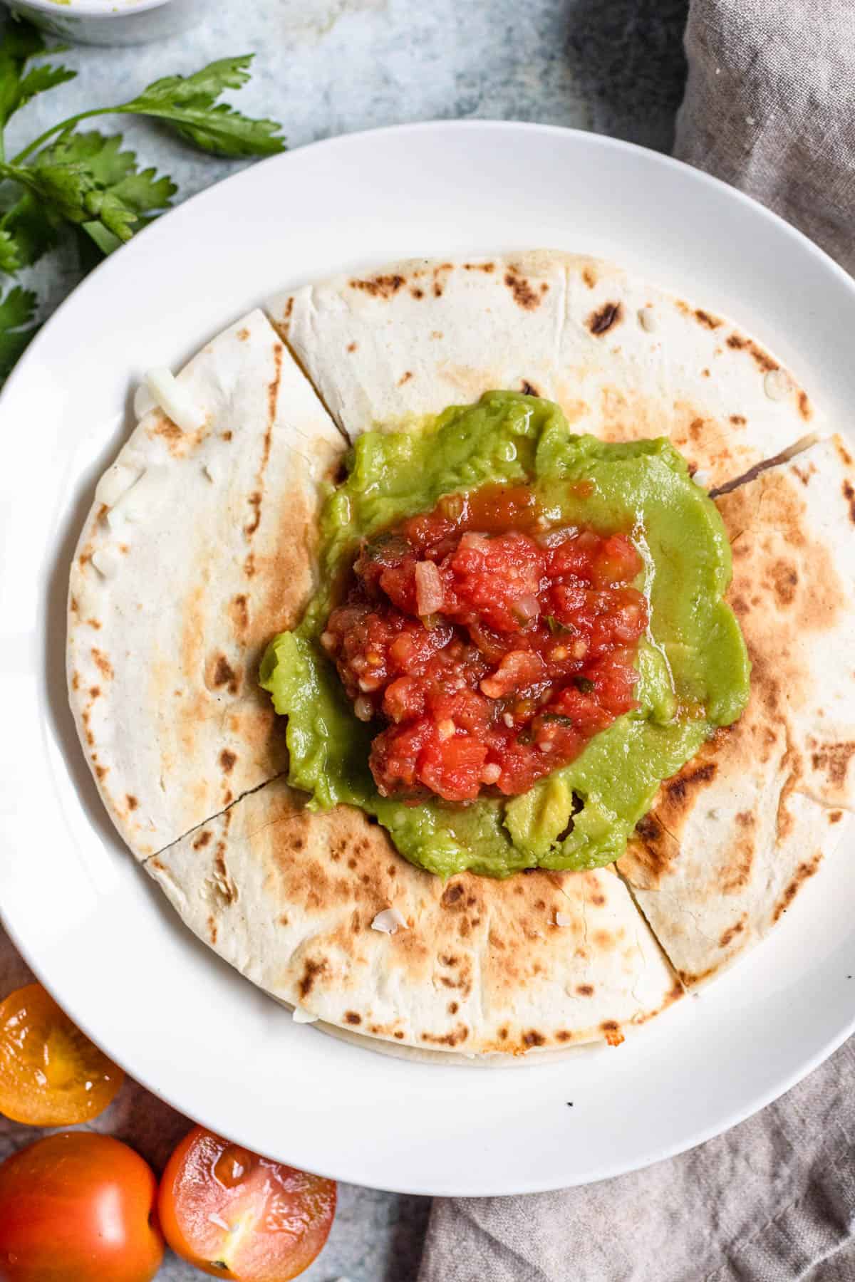 Sincronizadas on a plate, cut into fours and topped with guacamole and salsa. 